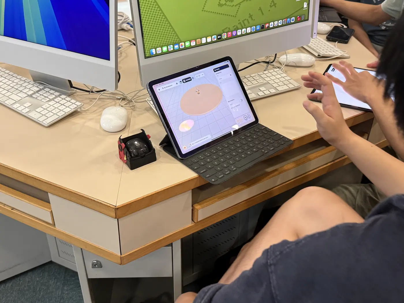 電腦室課堂上,學生同時使用 iPad 和電腦創作