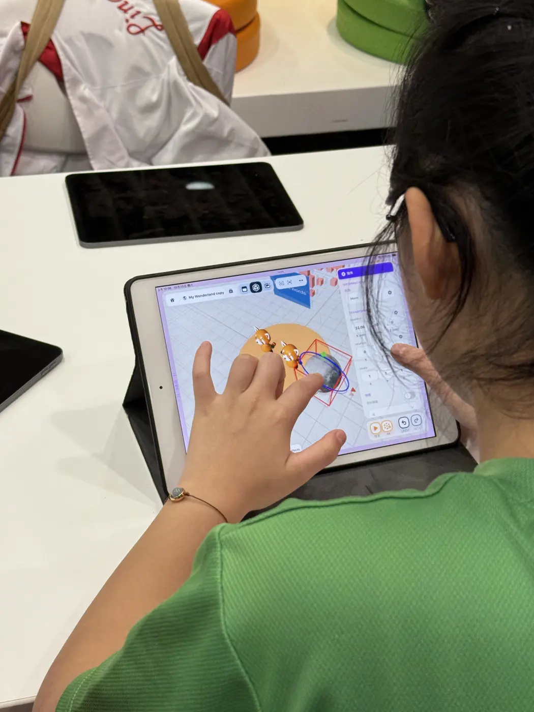 學生用手指在 iPad 上調整 3D 物件